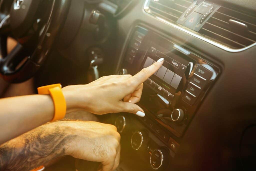 Couple's hands setting up their car audio system